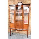 AN EDWARDIAN MARQUETRY INLAID DISPLAY CABINET the central concave glazed section over bowfront base,