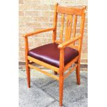 AN OAK ARMCHAIR the slat back with central pierced splat, drop-in seat, on square tapering