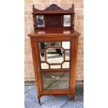 AN OAK MUSIC CABINET having a raised back above a door with a bevelled mirrored glass top, opening