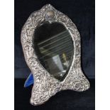 AN EDWARDIAN LARGE SILVER FRONTED HEART SHAPED MIRROR ON STAND The mirror front-mounted in silver,