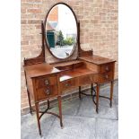 AN EDWARDIAN MAHOGANY DRESSING TABLE with marquetry and line inlaid decoration, the oval mirror