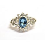 A 9CT GOLD DIAMOND GEM SET CLUSTER RING the oval facetted turquoise coloured gem set in a cluster of