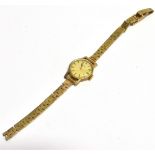 A LADY'S VINTAGE WRISTWATCH on a gold strap, the champagne dial fitted with gilt batons and