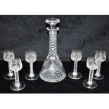 A DECANTER AND MATCHING SET OF SIX GLASSES each with facet cut decoration and engraved with vines