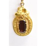 A GARNET SET PENDANT PIECE the facetted rectangular cut garnet raised and set in an ornate yellow