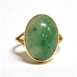A 9ct GOLD JADEITE COCKTAIL RING The oval stone measuring approx 1.8cm x 1.2cm on a shank with faded