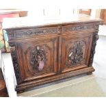 A LATE 19TH CENTURY FLEMISH CARVED OAK SIDE CABINET with pair of frieze drawers above doors