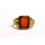 A GOLD SIGNET RING the bezel of a rectangular red hard stone setting, hallmarked for Birmingham