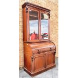 A VICTORIAN CYLINDER TOP BUREAU BOOKCASE the upper section with glazed doors enclosing three