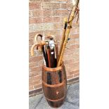 A COPPER BOUND COOPER OAK BARREL STICK STAND, together with a collection of assorted sticks