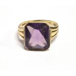 A VINTAGE 9CT GOLD PURPLE SAPPHIRE (SYNTHETIC) COCKTAIL RING The step cut faceted stone measuring