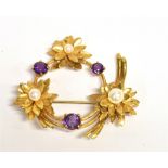 A 9CT GOLD WREATH BROOCH the brooch set with three purple pyropes and three simulated pearls, fitted