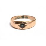A YELLOW METAL STAR GEM SET GYPSY RING The ring set with a dark blue sapphire on an unmarked