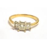 A THREE STONE PRINCESS CUT DIAMOND DRESS RING central diamond 0.4 x 0.4cm, two diamonds 0.3 x 0.