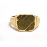 A 9CT GOLD SIGNET RING the ring with vacant bezel and diagonal pattern to the corners, rubbed