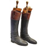 A PAIR OF GENTLEMAN'S BLACK LEATHER RIDING BOOTS with brown tops, size 10, complete with trees