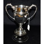 A SILVER TROPHY OF PLAIN FORM the twin handles with embossed decoration and with inscription: '