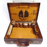 A BROWN LEATHER VANITY CASE with a faux crocodile skin finish, fitted with various potts, bottles