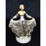 AN ART DECO PATINATED SPELTER FIGURE of a female holding dress with floral decoration, bearing '