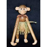 AN ARTICULATED WOODEN FIGURE OF A MONKEY IN THE MANNER OF KAJ BOJESON wearing a grass skirt and