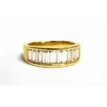 AN 18CT GOLD CHANNEL SET DIAMOND RING The ring set with 11 step cut diamonds each measuring