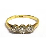 A EUROPEAN CUT DIAMOND THREE STONE RING The small diamonds set in platinum on a yellow metal band