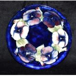 A MOORCROFT POTTERY 'PANSY' PATTERN DISH 18.5cm diameter, painted and impressed marks to base, paper