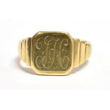 A YELLOW METAL SIGNET RING The ring with a monogrammed bezel and ribbed shoulders faded marks to the