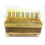 A HOHNER L'ORGANOLA PIANO ACCORDIAN uncased (some damage / loss to fretwork decoration).