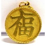 AN 18CT GOLD DISC PENDANT with raised Chinese character marks back and front, grooved pattern