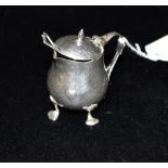 LIBERTY & CO: a hammered silver mustard pot, with strap loop handle, the waisted body embossed