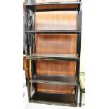 PIERRE VANDEL, PARIS: a four tier bookcase with black metal frame heightened in gilt and glass inset