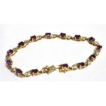 A 9CT GEM SET LINE BRACELET the bracelet set with alternating purple almandine (0.5 x 0.3cm) and