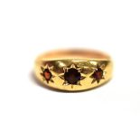 A GARNET PASTE STAR SET GYPSY RING the yellow metal shank unmarked, ring size M ¼, weight 2.2grams