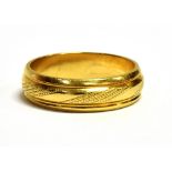 AN 18CT GOLD BAND RING the ring with textured pattern middle, width 0.5cm, import 750 stamp to the