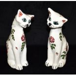 TWO C H BRANNAM BARUM WARE FIGURES OF SEATED CATS with painted floral decoration, 34cm high