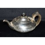 A SILVER TEAPOT the teapot of plain form, short spout, ribbed detail centre of belly, black ebonised