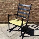 NIELS EILERSEN, DENMARK: a 1960s ebonised ladderback rocking chair with upholstered seat, 63cm wide,