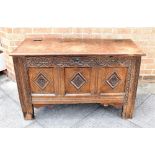 AN OAK COFFER the triple panel front with carved decoration, later top, 11cm wide 49cm deep 69cm