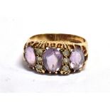 AN AMETHYST AND GOSHENITE DRESS RING the ring set with three facetted oval amethysts flanked by