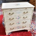 A CREAM PAINTED CHEST OF FOUR LONG DRAWERS beneath brushing slide, with floral painted decoration,