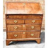 A MAHOGANY BUREAU the slope front opening to shelves, drawers and a well, above two short and two