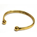 A 9CT GOLD TORQUE BANGLE the hollow bangle with ball ends hallmarked for Birmingham, weight 5.2grams