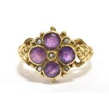 A 9CT GOLD, PURPLE ALMANDINE AND SEED PEARL CLUSTER RING the ring set with four faceted round cut