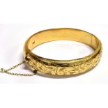 A GOLD PLATED SILVER BANGLE and safety chain the bangle with half patterned engraving, hallmarked