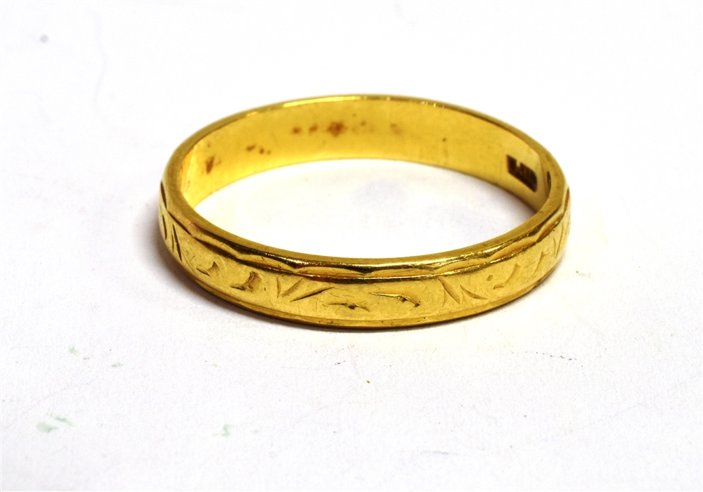 AN 18CT GOLD ENGRAVED PATTERN BAND RING The ring with faded hallmark, band width 0.4cm, ring size S,