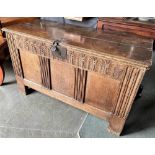A CARVED OAK COFFER with triple panel front, 116cm wide 51cm deep 69cm high