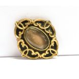 A MEMORIAL BROOCH/PENDANT the brooch in black enamel, the glass fronted hair panel mounted in yellow