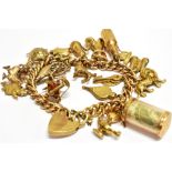 A 9CT GOLD AND YELLOW METAL CHARM BRACELET the bracelet comprising a yellow metal curb chain with