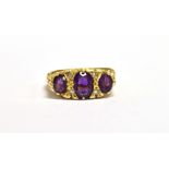 A PURPLE ALMANDINE AND DIAMOND DRESS RING the three almandines measuring 1.3 x 0.5cm, 0.4 x 0.3cm